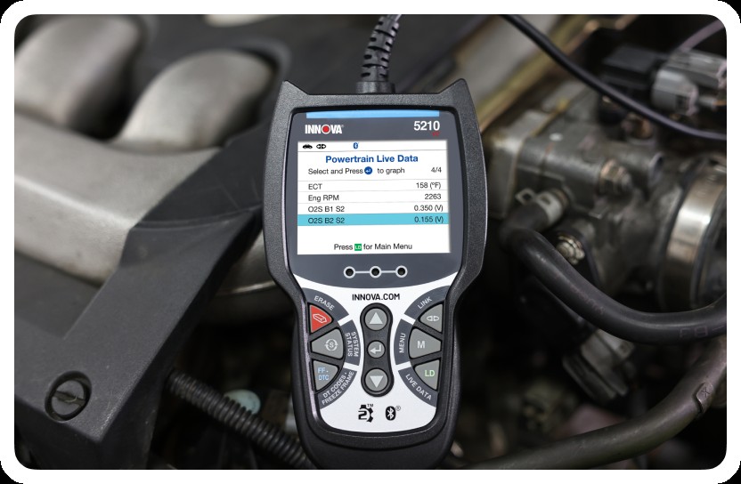 Image of a person using a handheld OBD2 scanner on a car, emphasizing user-friendly diagnostics