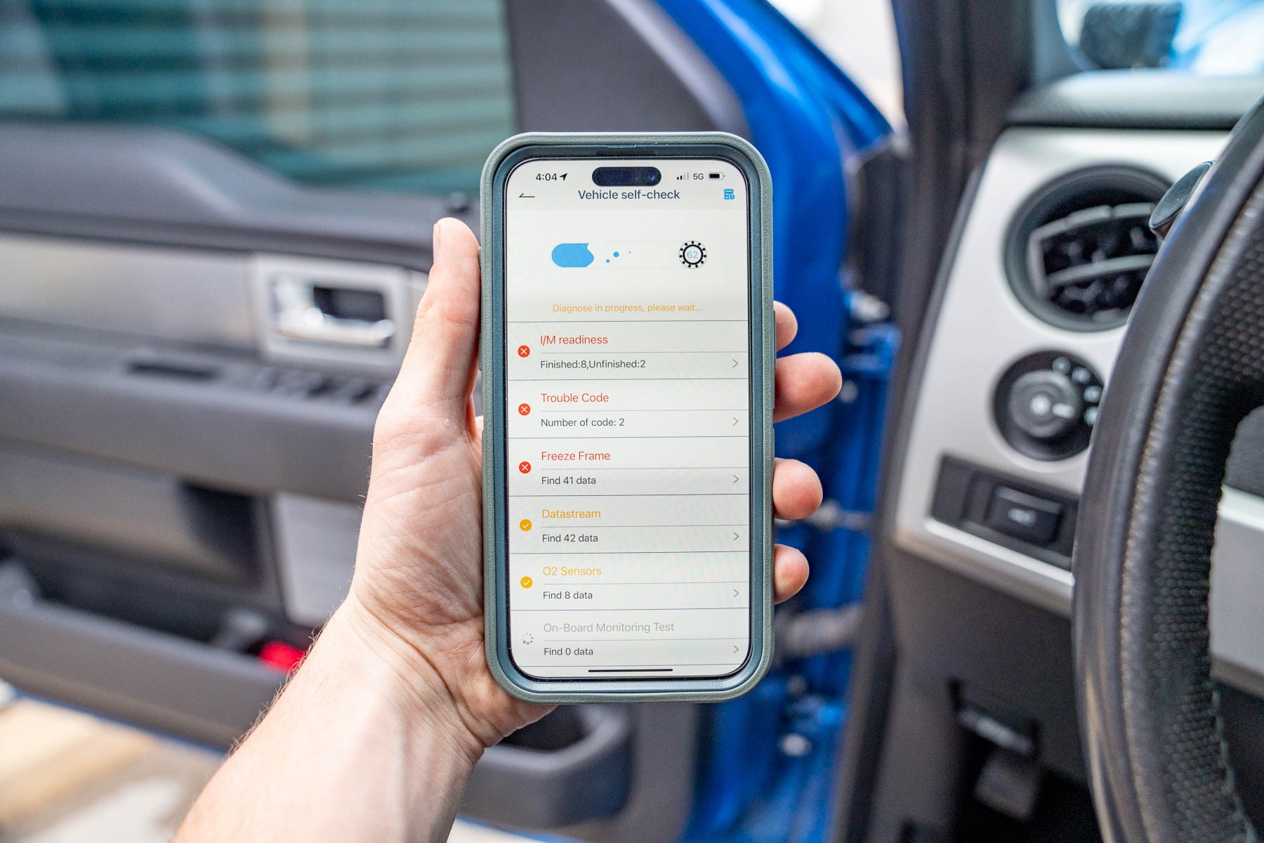 Driver using OBD2 scanner app on phone