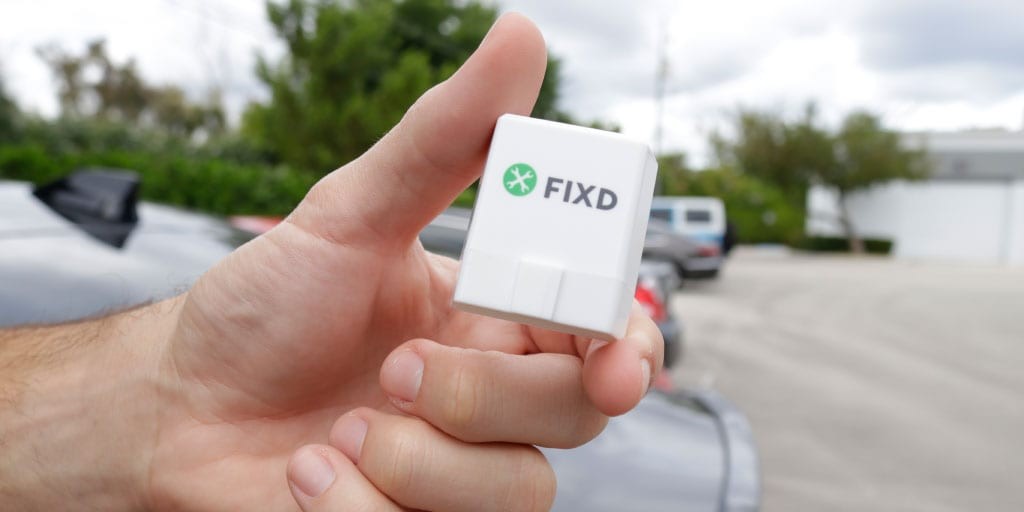 Close-up of the FIXD OBD2 sensor plugged into a car's OBD2 port.